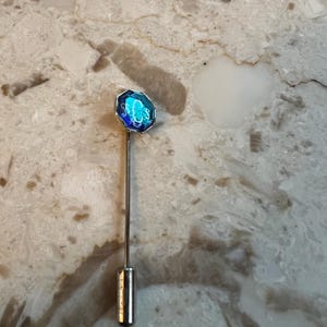 Vintage SCS Swarovski Crystal Society-stokspeld met blauwe steen en het Swarovski-logo erin.  Tweedehands en in zeer goede staat.