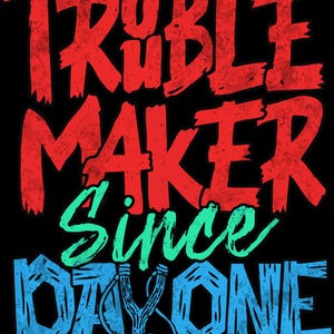 Puede incluir: Diseño gráfico negro con las palabras "TROUBLE MAKER" en rojo, "SINCE" en verde y "DAY ONE" en azul. Un gráfico de tirachinas está en el centro. El diseño tiene un aspecto envejecido y vintage.