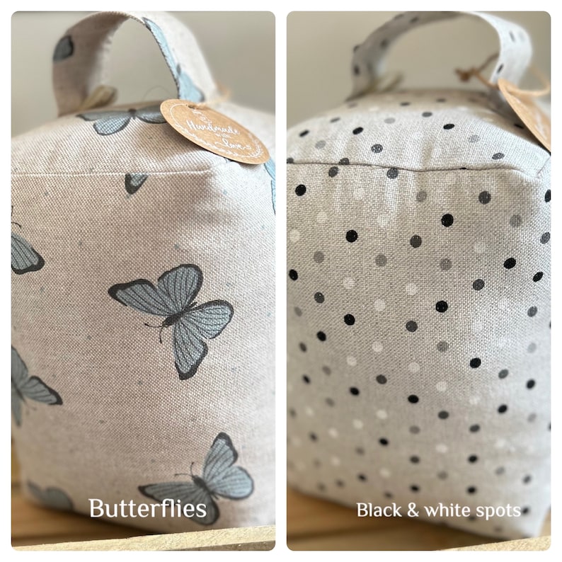 May include: Two doorstop cushions, one with a butterfly pattern and the other with black and white polka dots. Both cushions are made of a light beige fabric and have a loop handle.