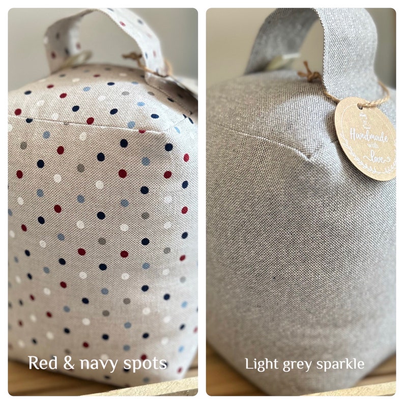 May include: Two doorstops, one with a light gray sparkle finish and the other with a beige fabric with red and navy blue polka dots. Both doorstops have a fabric handle and a tag that says "Handmade with Love".