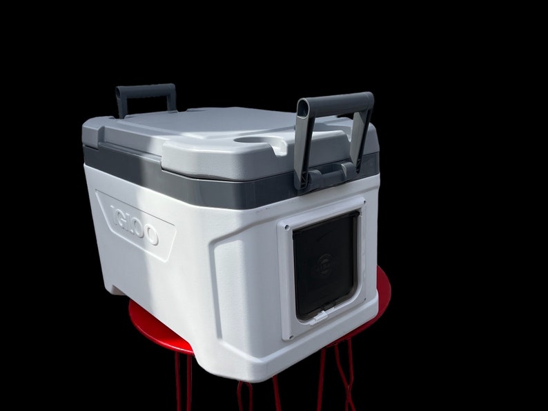 May include: White Igloo cooler with a black handle and a black door with a built-in bottle opener. The cooler is sitting on a red metal stool.