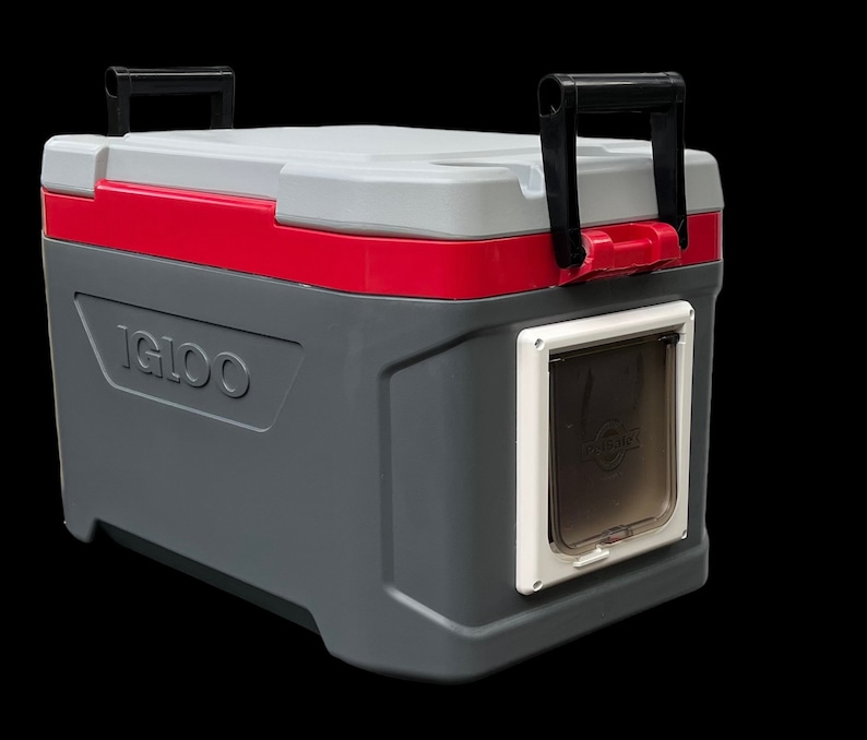 May include: A gray and red Igloo cooler with a white pet door on the side. The cooler has a black handle on the top.