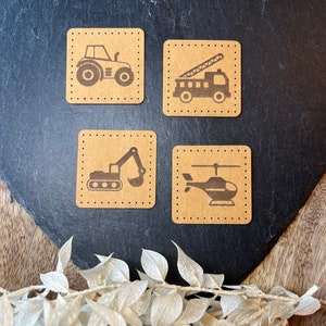 Könnte beinhalten: Vier braune quadratische Karten mit weißen gepunkteten Rändern. Jede Karte zeigt die Silhouette eines anderen Fahrzeugs: ein Traktor, ein Feuerwehrauto, ein Bagger und ein Hubschrauber.