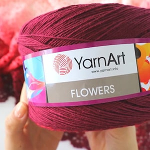 May include: A skein of burgundy yarn with a label that reads "YarnArt" and "FLOWERS" with a colorful floral design.