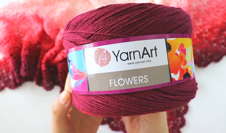 May include: A skein of burgundy yarn with a label that reads "YarnArt" and "FLOWERS" with a colorful floral design.
