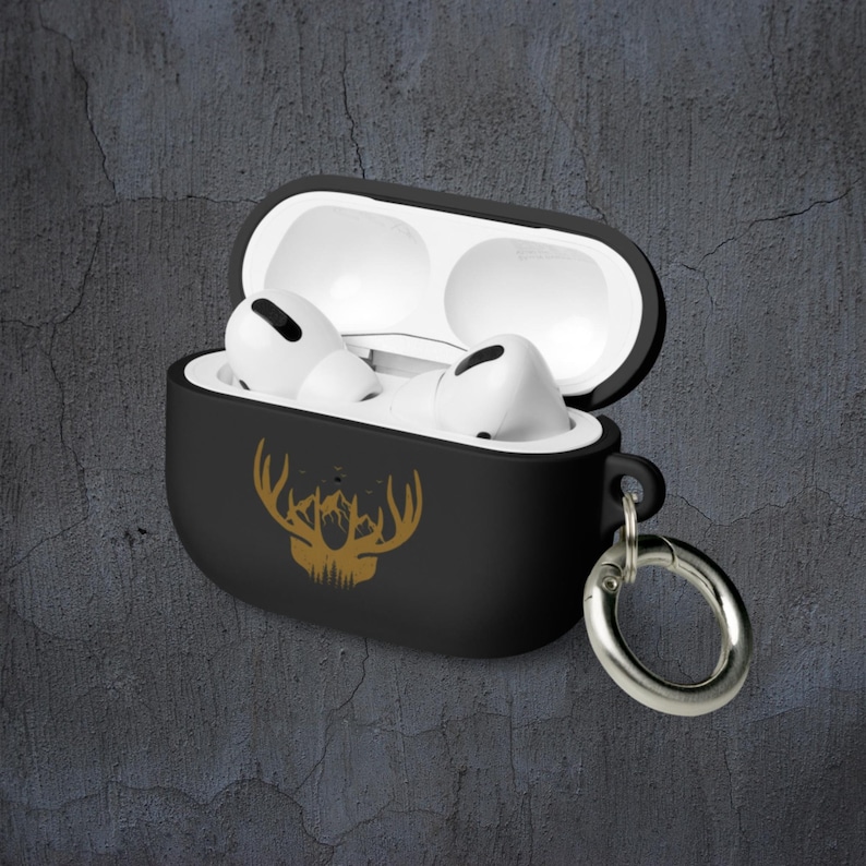 May include: Black Airpods case with a gold mountain and antlers design. The case has a black carabiner clip attached.