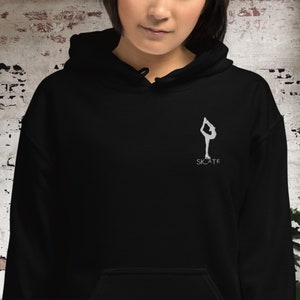 May include: Black hoodie with a white silhouette of a figure ice skating and the word "SKATE" underneath.