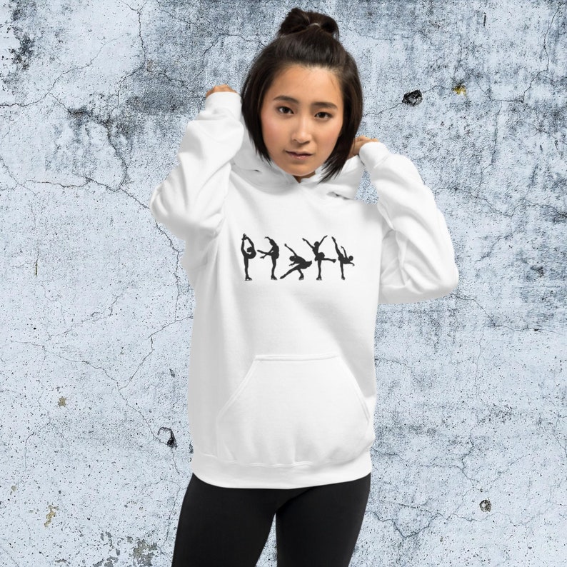 May include: White hooded sweatshirt with a black silhouette of figure skaters in various poses. The sweatshirt has a kangaroo pocket.