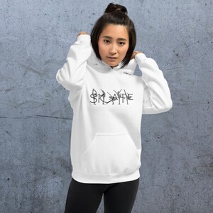May include: White hoodie with a black graphic of ice skaters forming the word "SKATE".