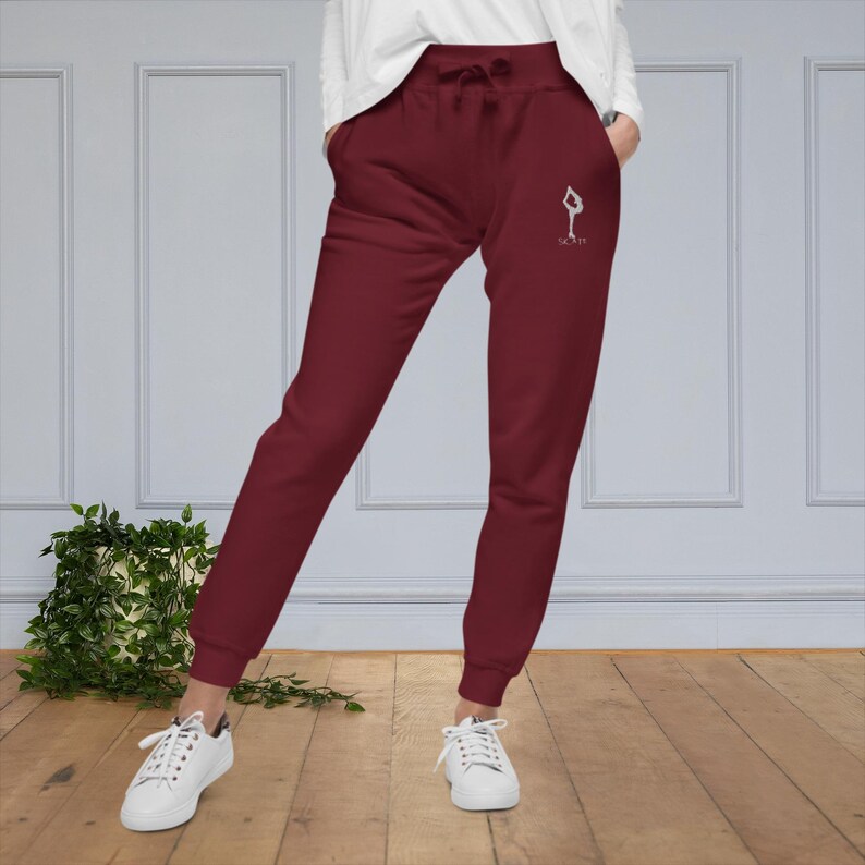 May include: Burgundy sweatpants with a white graphic of a person doing a yoga pose and the text "Slay It".