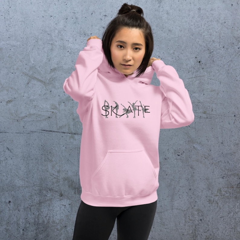 May include: A pink hoodie with a black graphic of ice skaters spelling out the word "SKATE".