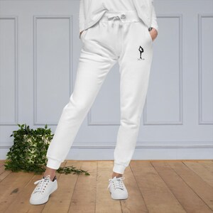 May include: White sweatpants with a black yoga pose graphic and the text "CALM" on the right leg.