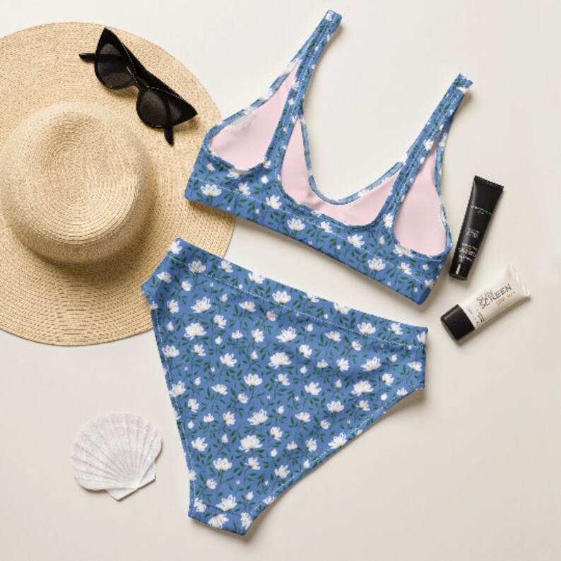 May include: A blue and white floral print bikini top and bottom. The top has a scoop neck and adjustable straps. The bottom is a high-waisted style.