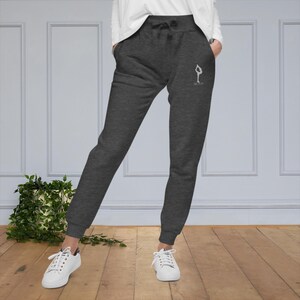 May include: Gray sweatpants with a white graphic of a person doing a yoga pose and the text "Savasana".