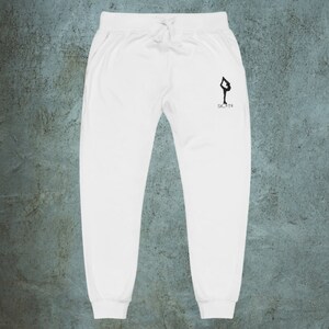 May include: White sweatpants with a black silhouette of a figure in a yoga pose and the word "SKATE" printed on the left leg.