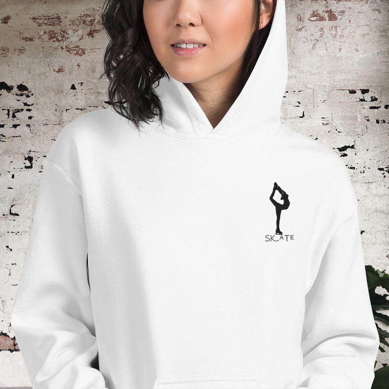 May include: White hoodie with a black silhouette of a figure ice skating and the word "SKATE" underneath.