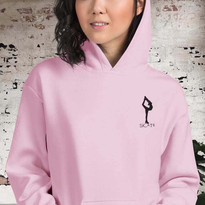 May include: Pink hoodie with a black silhouette of a figure ice skating and the word "SKATE" underneath.