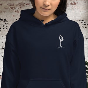 May include: A navy blue hoodie with a white silhouette of a figure ice skating and the word "SKATE" underneath.