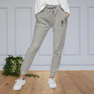 May include: Gray sweatpants with a black silhouette of a person doing a yoga pose and the text "FLOW" on the right leg.