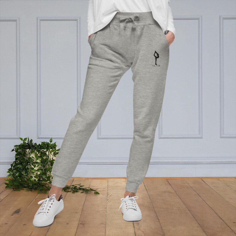 May include: Gray sweatpants with a black silhouette of a person doing a yoga pose and the text "FLOW" on the right leg.