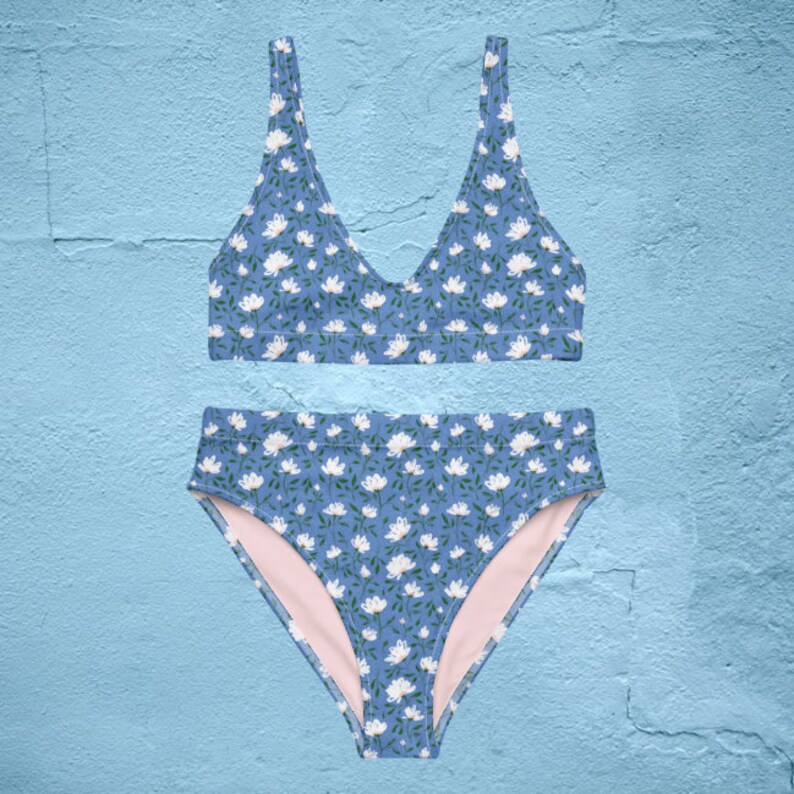 May include: A blue and white floral print bikini top and bottom. The top has a v-neck and the bottom is high-waisted.