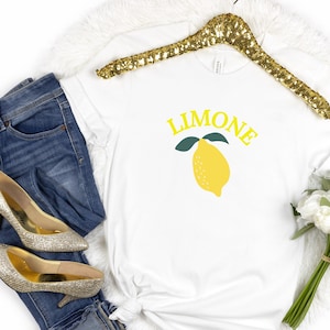 May include: White t-shirt with a yellow lemon graphic and the word "LIMONE" in yellow letters.