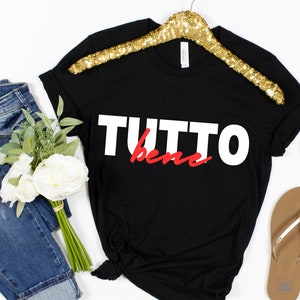 May include: Black t-shirt with white text that says "TUTTO bene" in red.