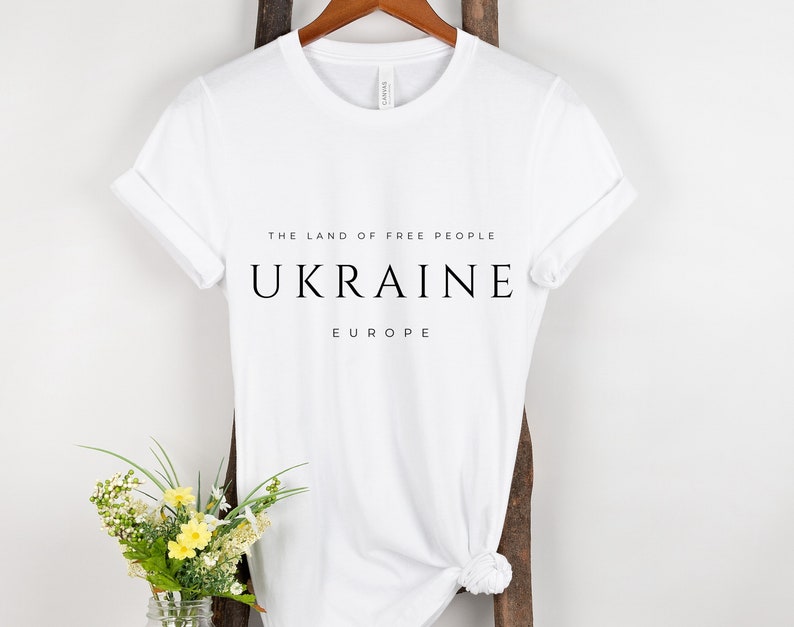 Pu&ograve; includere: Maglietta bianca con testo nero che recita "The land of free people, Ukraine, Europe".