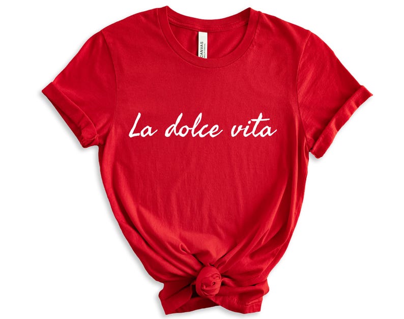 May include: Red short-sleeved t-shirt with the text "La dolce vita" in white.