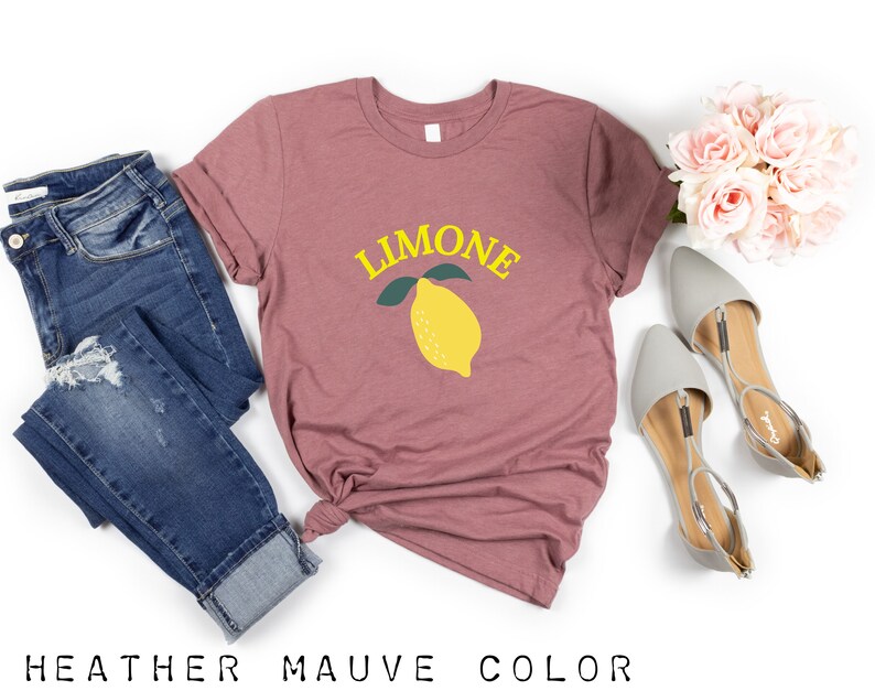 May include: A heather mauve t-shirt with the word "LIMONE" in yellow letters and a yellow lemon with green leaves.