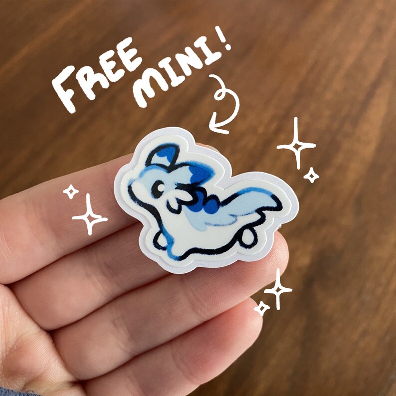 May include: A white and blue dragon sticker with a white outline. The sticker is on a hand and has the text "FREE MINI!" written above it.
