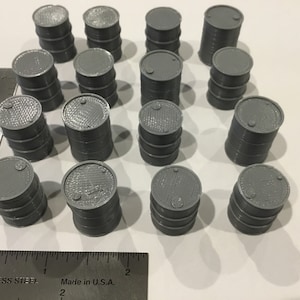 May include: A collection of 16 gray plastic barrels, stacked in various configurations. The barrels are approximately 2 inches in diameter and 3 inches tall.
