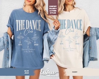 May include: Two t-shirts, one blue and one ivory, with the text "THE DANCE Club" and ballerina illustrations. The shirts also include "EST. 2025" and "Dance School, City State". The blue shirt is labeled "BLUE JEAN".