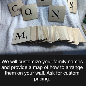 May include: Wooden Scrabble tiles spelling out the word "CONS" with a separate tile for the letter "M". The tiles are arranged on a white surface. The text "We will customize your family names and provide a map of how to arrange them on your wall. Ask for custom pricing." is visible below the tiles.