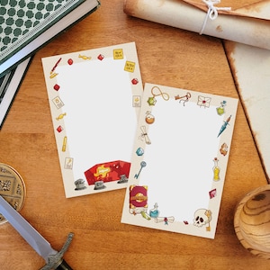 以下が含まれることがあります： 白い背景と、ファンタジーや冒険のアイテムを描いたカラフルな漫画の画像の境界線を持つ、印刷可能な紙のシートが2枚。境界線には、鍵、ポーション、巻物、サイコロ、頭蓋骨の画像が含まれています。