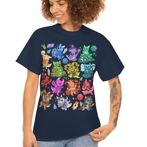 May include: A navy blue t-shirt with a colorful graphic print of various cartoon creatures. The creatures are all different colors and have different expressions. The shirt is a relaxed fit and has a crew neck.