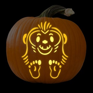May include: A carved pumpkin with a friendly monster face illuminated from inside. The monster has large eyes, a wide smile, and small feet.