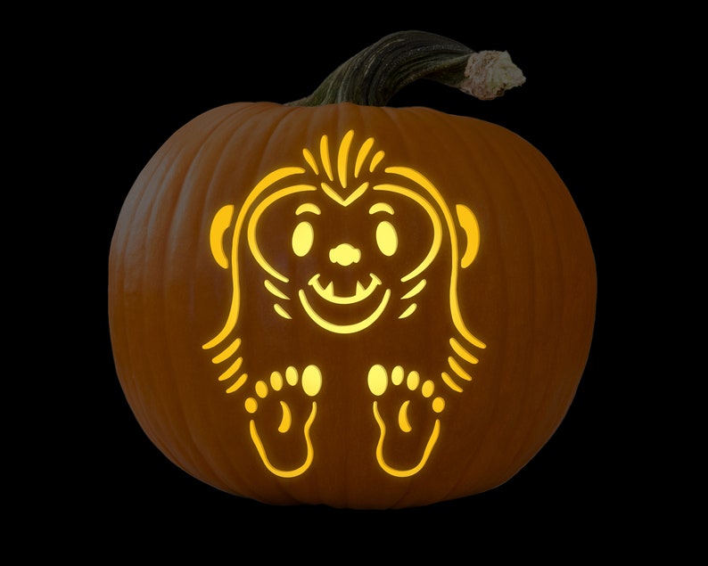 May include: A carved pumpkin with a friendly monster face illuminated from inside. The monster has large eyes, a wide smile, and small feet.