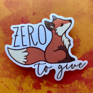 May include: A white sticker with a cartoon fox sitting on its haunches. The fox is orange with a white belly and a white tail. The text "zero to give" is written below the fox.