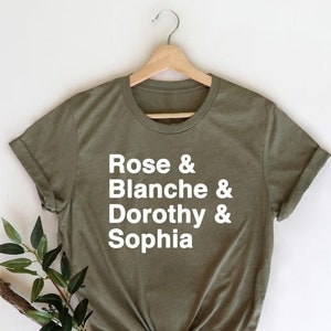 May include: A green t-shirt with white text that reads "Rose & Blanche & Dorothy & Sophia".