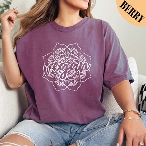 a woman sitting on a couch wearing a purple shirt