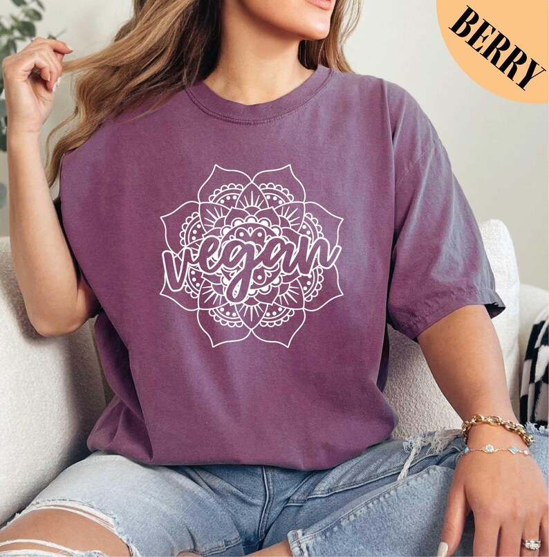 a woman sitting on a couch wearing a purple shirt