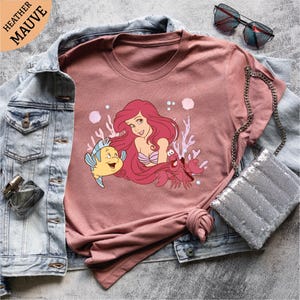 a pink shirt with a little mermaid on it