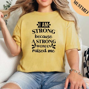 a woman wearing a t - shirt that says i am strong because a strong woman