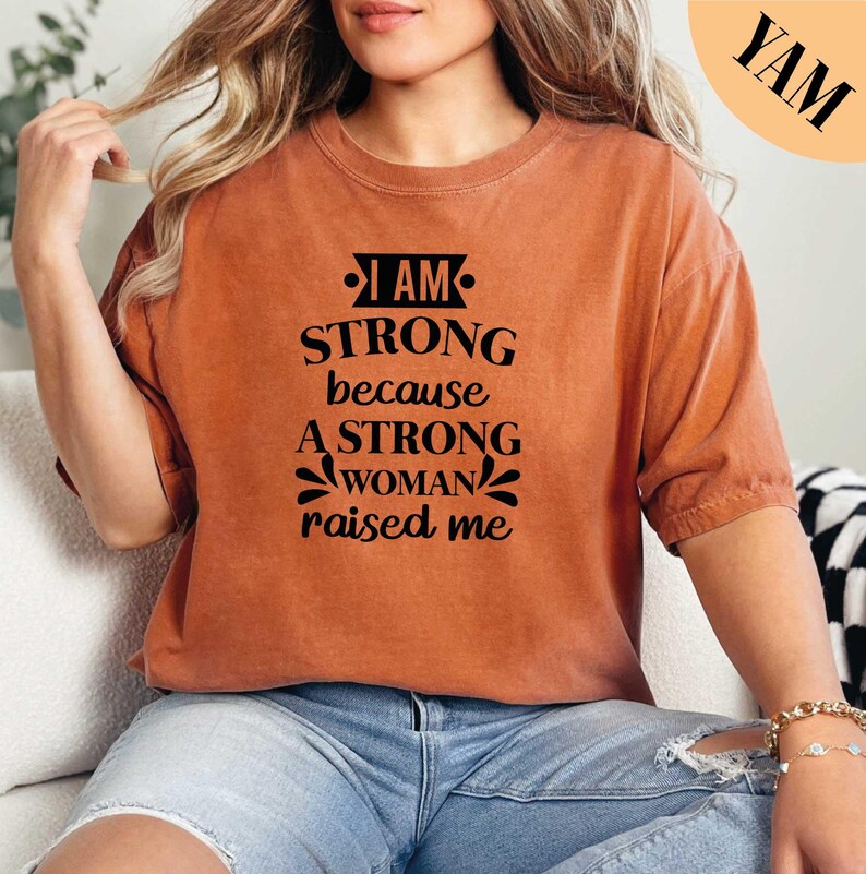 a woman sitting on a couch wearing a brown shirt