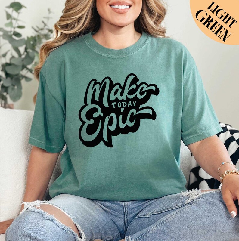 a woman sitting on a couch wearing a t - shirt that says make today epic