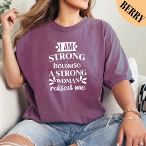 a woman wearing a t - shirt that says i am strong because a strong woman