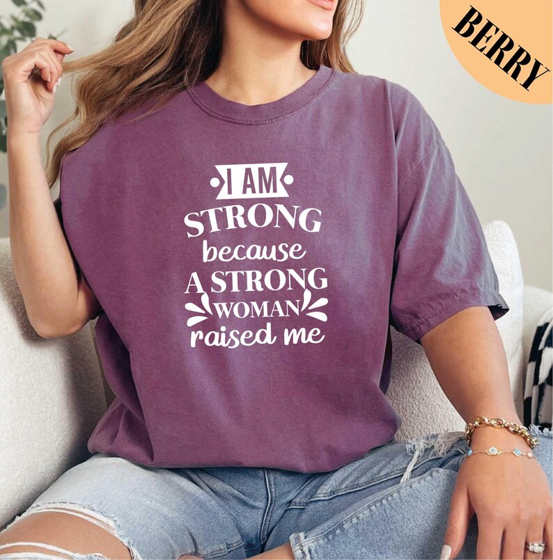 a woman wearing a t - shirt that says i am strong because a strong woman