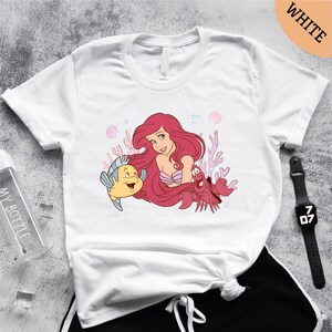 a t - shirt with an image of a mermaid and a fish on it