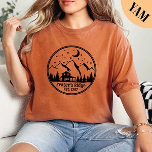 a woman sitting on a couch wearing a brown shirt